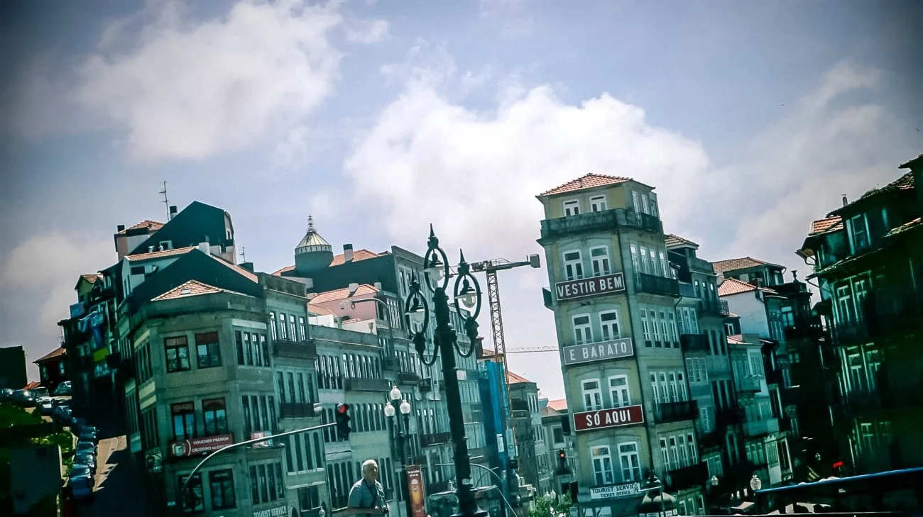 Historic buildings in downtown Porto with a “Vestir Bem e Barato” sign