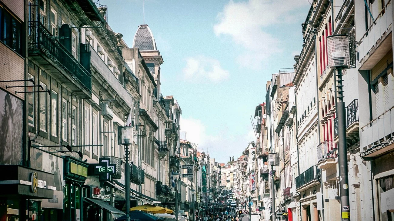 A bustling shopping street lined with classic European architecture