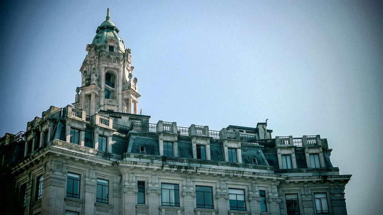 An ornate Beaux-Arts building with a green-domed tower