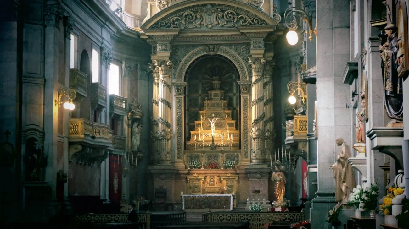 The gilded main altar inside a Porto church, bathed in warm light