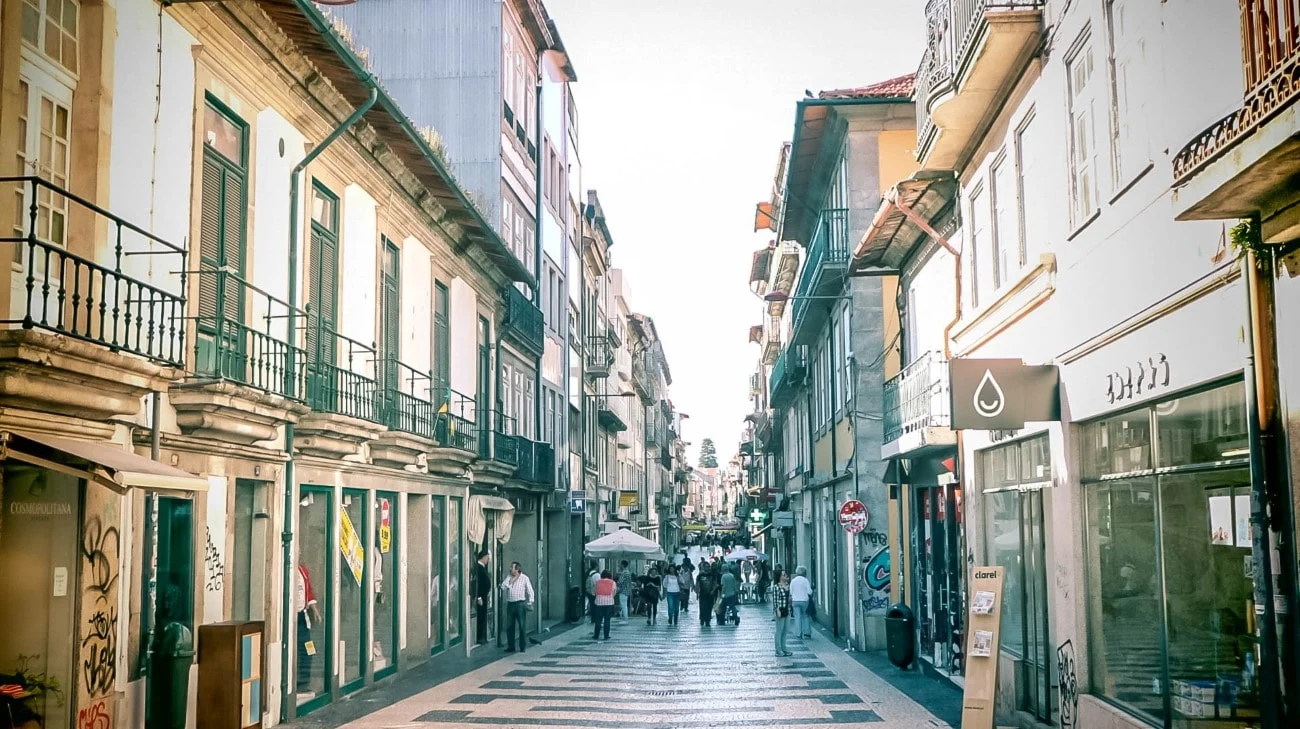 A narrow pedestrian street lined with shops and traditional buildings