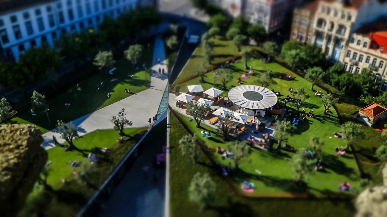 A park with a circular café pavilion and people lounging on the grass, seen from above