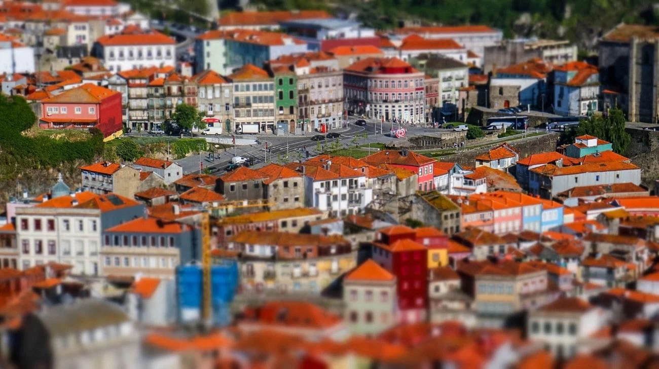 Tilt-shift view of a small plaza surrounded by colorful buildings on the hillside