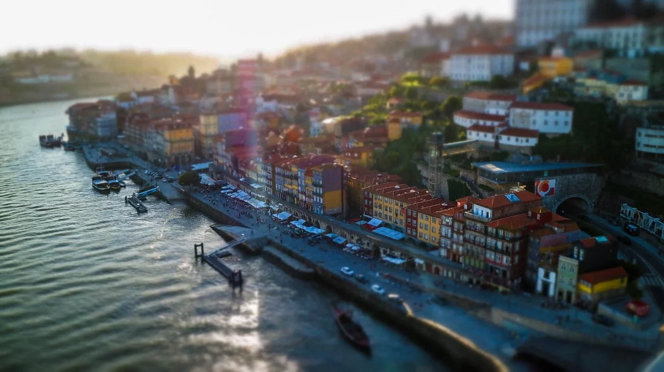 Tilt-shift aerial view of the colorful Ribeira waterfront along the Douro