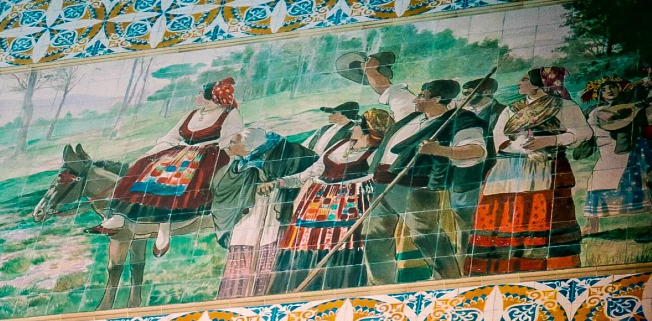 Colorful tile mural of Portuguese folk in traditional dress inside São Bento station