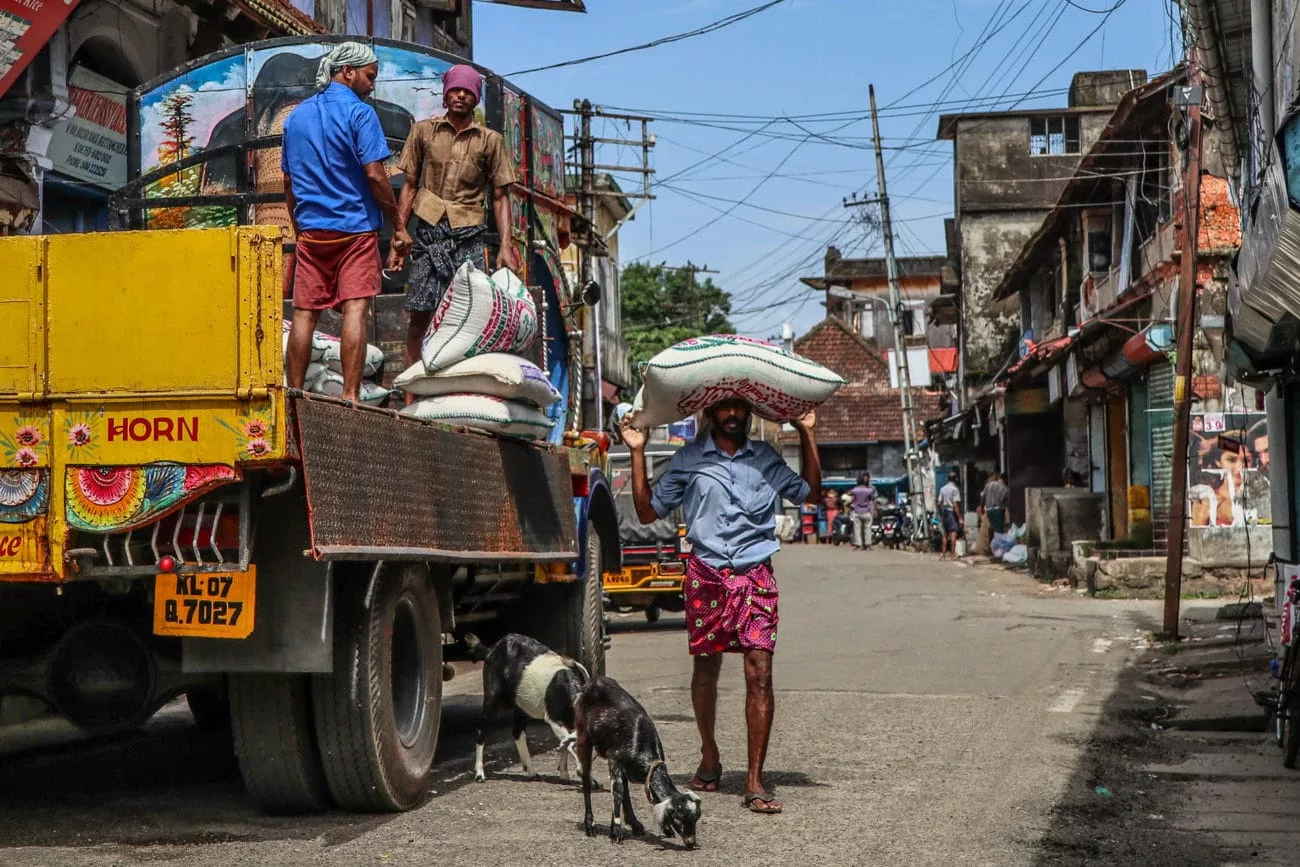 Männer entladen Säcke mit Waren in Fort Kochi