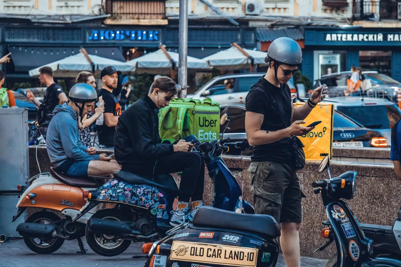 Les chauffeurs Uber et Glovo attendent leur prochaine livraison à Kyiv