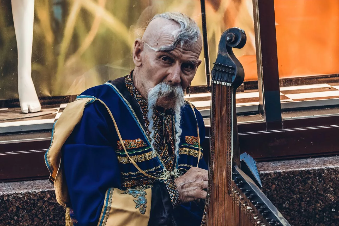 Un homme ukrainien en tenue traditionnelle joue de son instrument sur la rue Khreschatyk