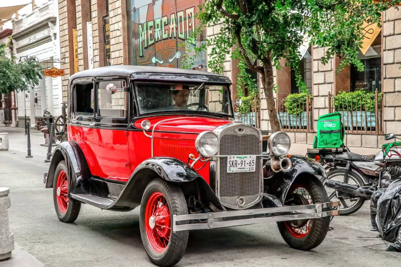 A man drives around in a classic car in the streets of Barrio Antiguo