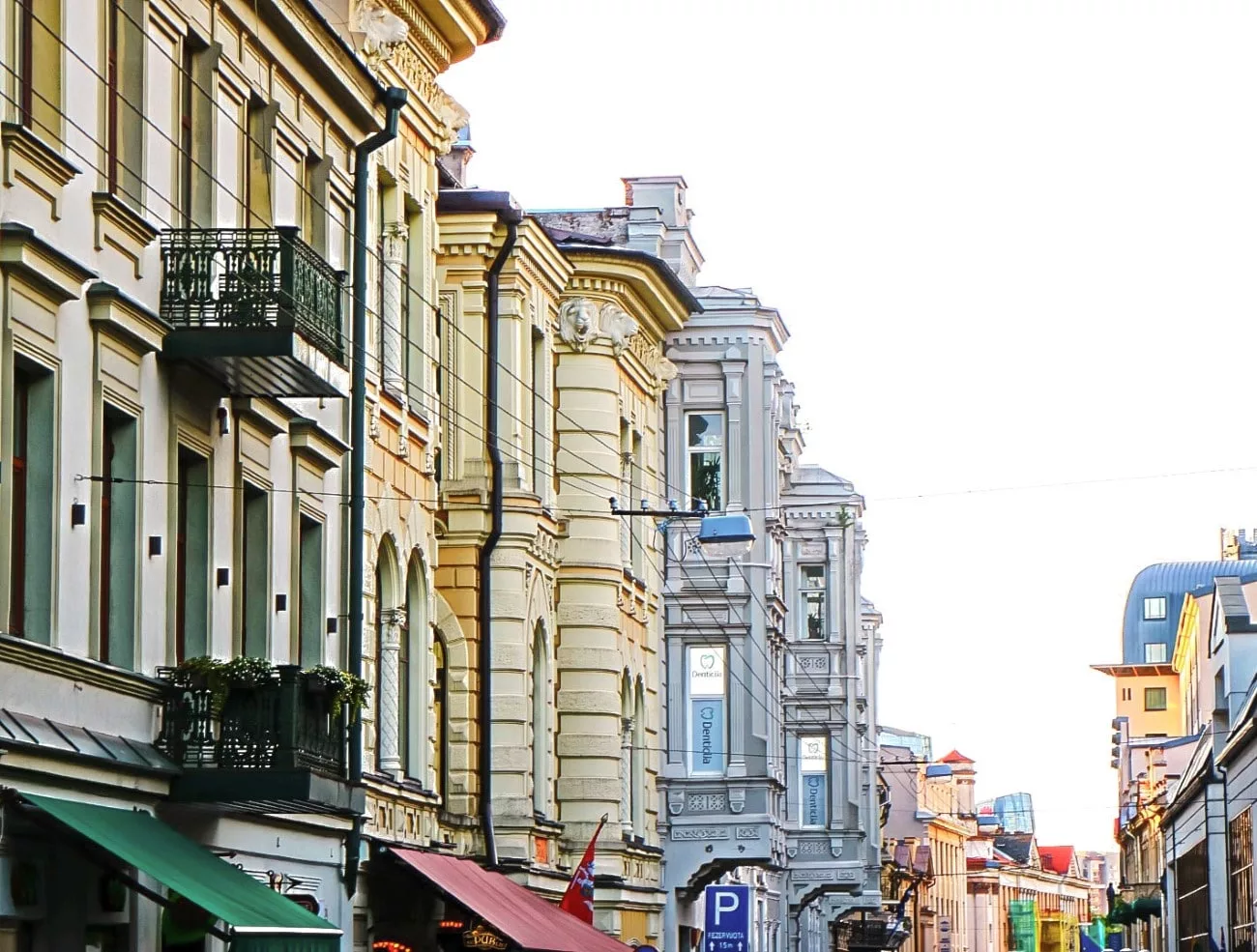 Wrought-iron balconies and pastel facades along a quiet Old Town street