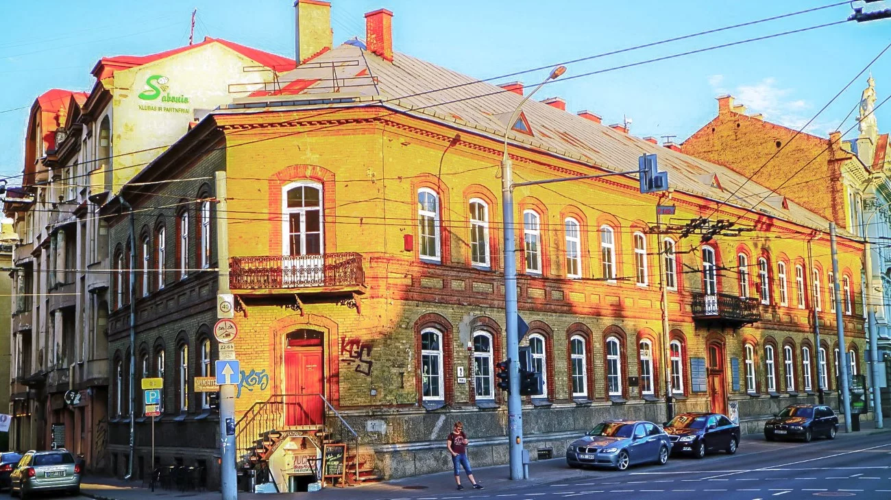 Yellow brick and red-tile rooftops on a street corner near Halles Market