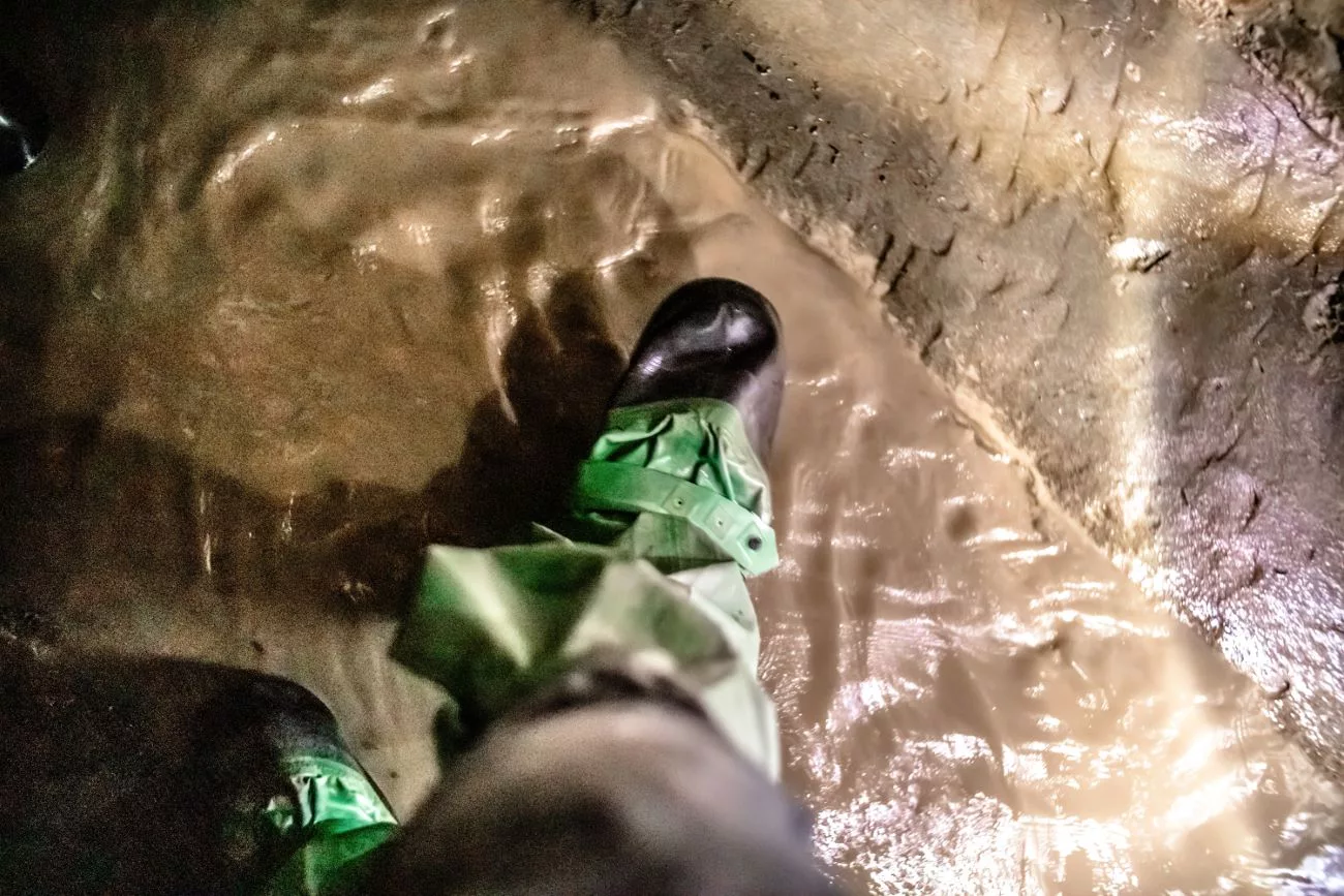 Wir trugen Gummistiefel, um durch die Tunnel zu kommen