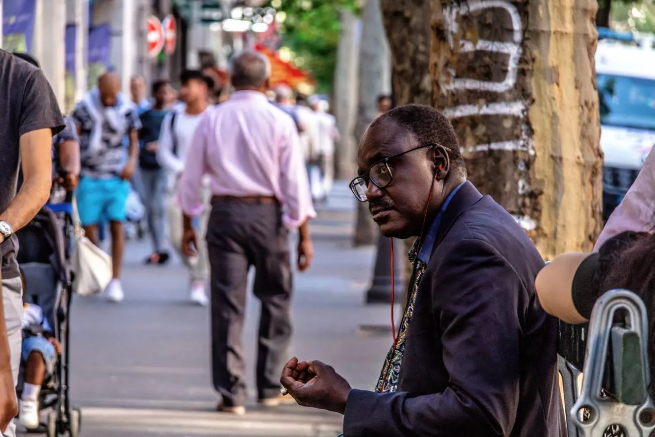 Un homme écoute de la musique assis sur un banc à Paris