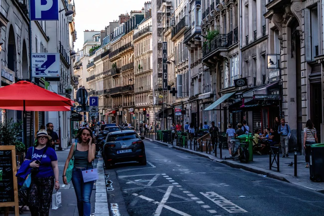 Les immeubles étroits du XVIIIe siècle surplombent les rues de Paris le soir