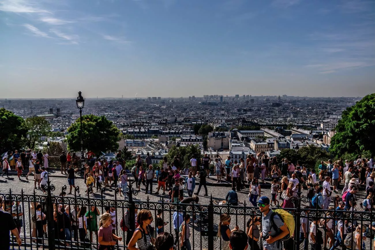 Un flot de touristes visite Paris chaque jour, sans fin — Une vue de Paris à midi, depuis le Sacré-Cœur