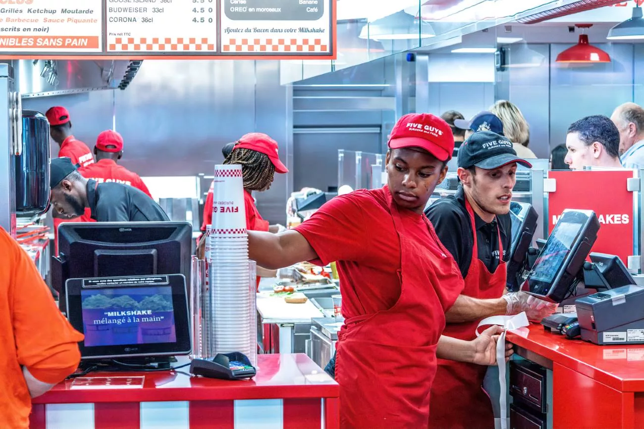 Préparation de nourriture au restaurant de burgers Five Guys à Paris