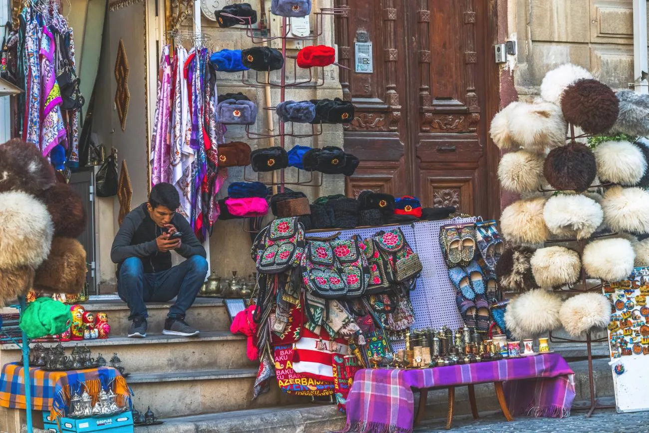 Ein Mann verkauft Souvenirs und Hüte in Icherisheher (Altstadt von Baku)